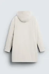 Parka color crudo de tejido técnico acolchado, con cuello alto y capucha ajustable. Tiene mangas largas con puños ajustables, bolsillos frontales con solapa, bolsillo interior y cierre frontal con cremallera oculta por solapa con botones a presión.