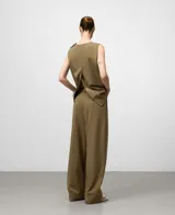 Top recto sin mangas, color verde oliva, con cuello redondo y cierre de dos botones en el hombro izquierdo. Presenta aberturas laterales en el delantero.