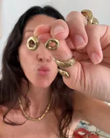 Par de aros dorados con forma cuadrada irregular y centro hueco.