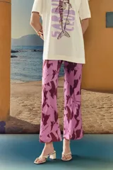 Pantalón de corte recto color rosa con estampado floral abstracto en tonos borgoña.