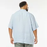Camisa celeste de lino con cuello clásico, manga corta y cierre frontal con botones.