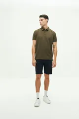 Remera polo verde militar con textura, corte regular, cuello clásico con detalles en azul marino y logo estampado en el pecho.
