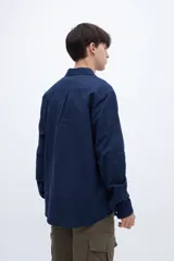 Camisa celeste de algodón, corte regular fit, con cuello solapa clásico, manga larga, bolsillo en el pecho y botones personalizados.