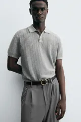 Polo gris de punto con textura, corte regular, cuello solapa y cierre frontal con botones.