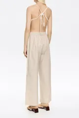 Pantalón corte jogger color beige, con largo tobillero, bolsillos tipo alforja y logo bordado. Cintura elástica ajustable con cordones.