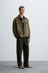 Sobrecamisa color beige de tejido efecto ante, corte regular fit, con cuello solapa, manga larga con puños abotonados, bolsillos de parche con solapa en el pecho y bolsillos de ojal en la cadera.