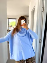Sweater celeste de tejido de punto, con cuello alto y mangas largas.