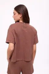 Remera color chocolate de corte holgado, con cuello redondo y mangas cortas con dobladillo. Estampado pequeño en el pecho con logo de frutas.