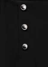 Pantalón largo de mujer, color negro, de diseño wideleg y tiro medio. Presenta detalle metálico y cierre de cremallera lateral.