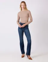 Jean elastizado de mezclilla azul oscuro, tiro alto, con pierna bootcut. Presenta costuras visibles y cinco bolsillos.