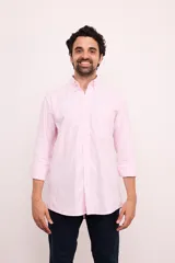 Camisa de algodón a rayas verticales rosas y blancas, de corte clásico, con cuello abotonado, bolsillo en el pecho y mangas largas con puños abotonados.