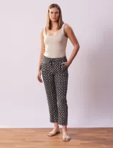 Pantalón negro con estampado geométrico blanco, de corte recto, con pretina ancha elastizada y lazo de ajuste.