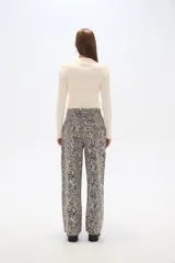 Pantalón ancho de algodón con estampado abstracto en tonos beige y negro, de tiro alto y con bolsillos laterales.