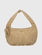 Cartera tipo hobo color beige de gamuza sintética con tachas doradas en el borde. Tiene un asa de hombro y un dije colgante con el logo de la marca.