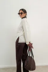 Sweater de punto gris con cuello en V y ribetes en contraste.