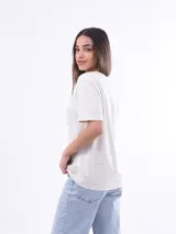 Remera negra de algodón con cuello redondo y mangas cortas. Estampado frontal con la frase "World Tour Vacation State of Mind" en letras de colores y un pequeño dibujo de una palmera.