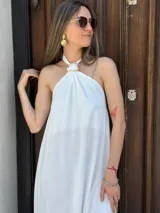 Vestido largo blanco con cuello halter y espalda descubierta.