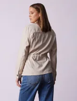 Sobrecamisa blanca de lino y rayón, marca Dash, con cuello solapa, abertura central con botones, bolsillos delanteros y cintura ajustable con jareta interna.