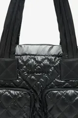 Bolso confeccionado en nylon matelassé negro, con manijas y correa desmontable, cuenta con múltiples bolsillos y división para notebook.