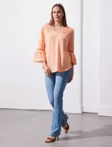 Blusa color celeste con escote en V, mangas largas acampanadas con detalle de crochet y frunces en los hombros.