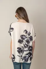 Blusa italiana de calce holgado, talle único, con cuello redondo y mangas cortas. Estampado de flores sobre fondo natural.