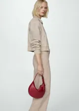 Pantalón culotte color beige de tejido tejano vaquero elástico, con tiro alto, trabillas, bolsillos delanteros y traseros, cierre de cremallera y botón, y bajo deshilachado.