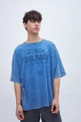 Remera celeste con efecto marmolado y estampa en el pecho, de corte boxy y mangas cortas.