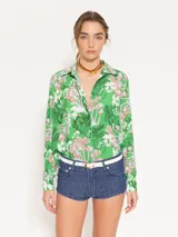 Camisa de viscosa con estampado de hongos en tonos verdes, celestes y rosados. Tiene corte relajado, cartera oculta y botones de pasta teñidos a tono con logo marcario.