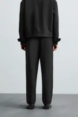 Pantalón negro de corte recto, con cintura elástica, bolsillos laterales y trasero.