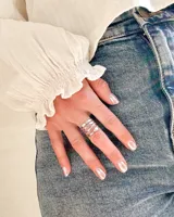 Anillo plateado de acero, con diseño de tres bandas onduladas.
