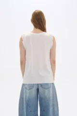 Remera azul de viscosa con cuello redondo y mangas cortas con volados. Corte holgado y largo a la cadera.