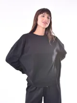 Buzo negro de corte holgado y cuello redondo.