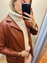 Blazer de cuero sintético color chocolate con cuello solapa y bolsillos con tapa.