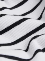 Minivestido blanco con rayas horizontales negras, de corte ajustado y breteles finos blancos.