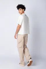 Remera color crudo de corte cuadrado y holgado, con cuello redondo y mangas cortas. Confeccionada en algodón pesado.