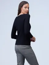 Buzo de tejido fino, color beige, con mangas tres cuartos estilo raglán.