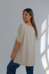 Blusa beige de lino con detalle de bordado floral y perforaciones en el lateral.