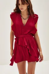Vestido corto color rojo, con escote en V, mangas cortas con volados y cintura elástica con lazo para ajustar. La falda presenta volados asimétricos.