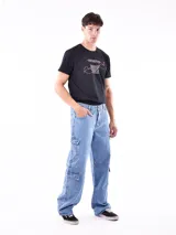 Pantalón de jean celeste de corte ancho, con bolsillos laterales tipo cargo.