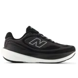 Championes New Balance modelo 1080 para mujer, color negro con detalles en gris claro y blanco. Presentan un diseño moderno con malla transpirable y una suela gruesa y curva de espuma blanca.