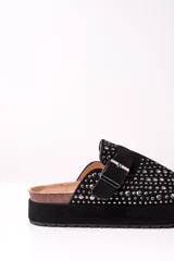 Zueco negro con plataforma, tachas plateadas y hebilla ajustable.