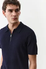 Remera polo de manga corta color azul marino en punto acanalado de mezcla de algodón con cuello y medio cierre. Remate acanalado de raya fina en mangas y bajo. Corte ajustado que realza el contorno del cuerpo creando una silueta entallada.