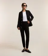 Pantalón legging negro de punto roma con botones dorados decorativos.