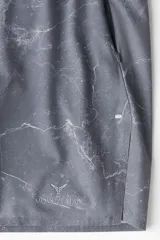 Short deportivo gris con estampado de mármol, con cintura elástica ajustable con cordón, bolsillos laterales con cierre y calza interior con bolsillo para celular.