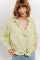 Camisa color crema de manga larga con cuello camisero y detalles de encaje en el escote. Se ata en la parte delantera.