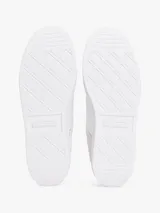 Zapatillas urbanas de corte bajo con exterior de ante blanco, detalles en gris y azul celeste, y refuerzo en el talón de cuero burdeos. Presentan el logo de la marca bordado en el lateral y en la parte trasera.