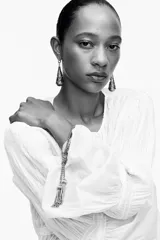 Aros metálicos dorados con forma de aro y colgante en forma de cono con textura labrada.