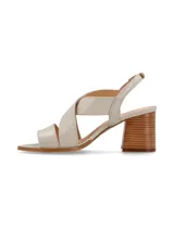 Sandalia de cuero color beige y blanco, con taco de madera y hebilla metálica.
