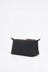 Neceser negro de nylon con estructura blanda y tamaño grande. Tiene cierre con cremallera, tirador de piel, logo metálico de la marca y un bolsillo interior.