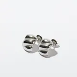 Par de aros tipo argolla gruesa, plateados, con forma irregular y textura acanalada.